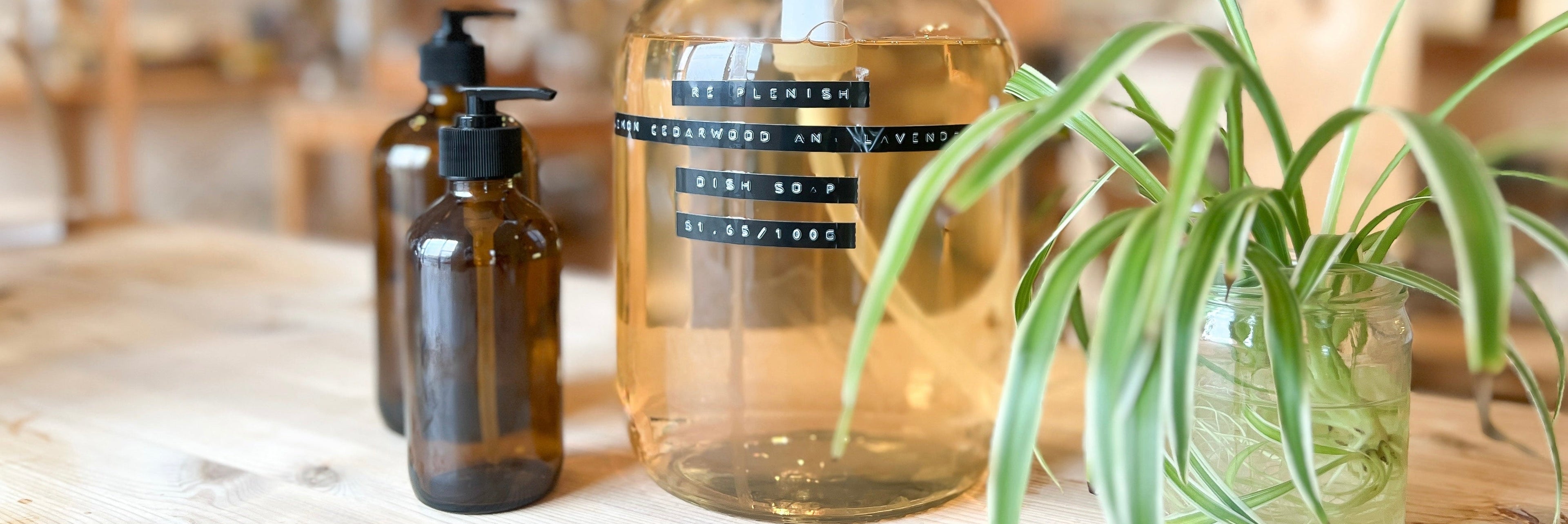 Refillable bottle of dish soap with jars and a plant